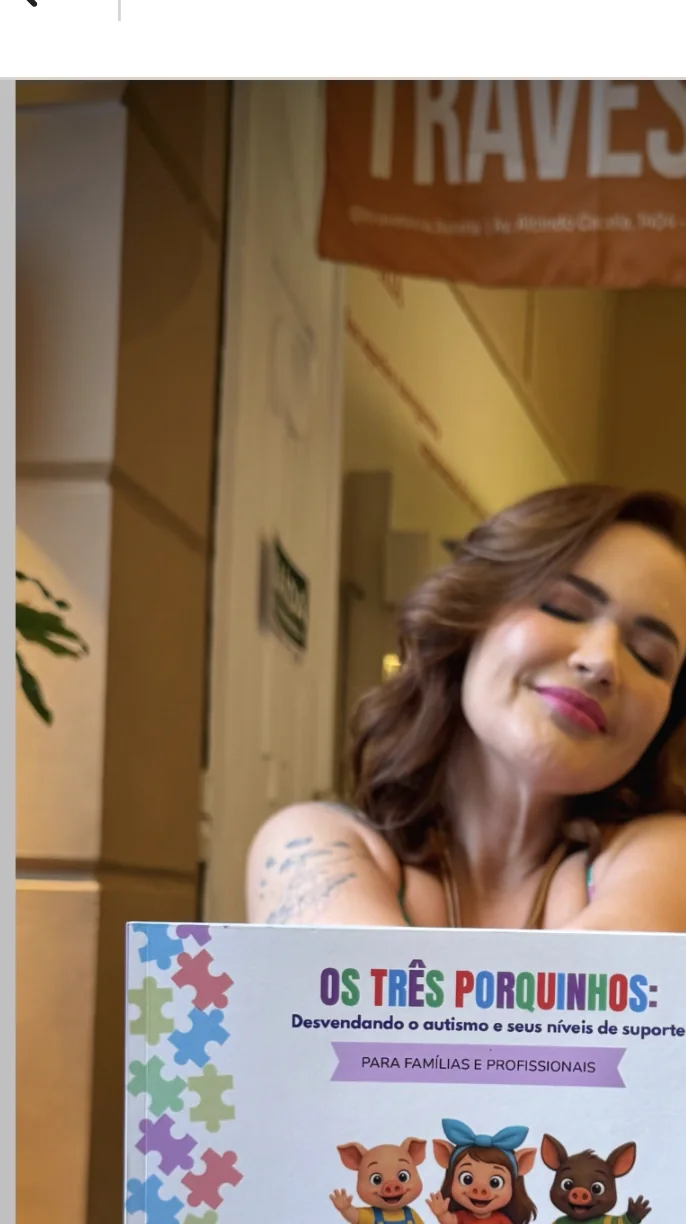 Priscila Caseiro de Oliveira segurando o livro em ambiente literário